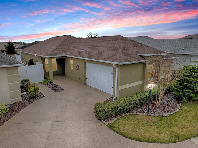 ranch-style home featuring a garage and a yard