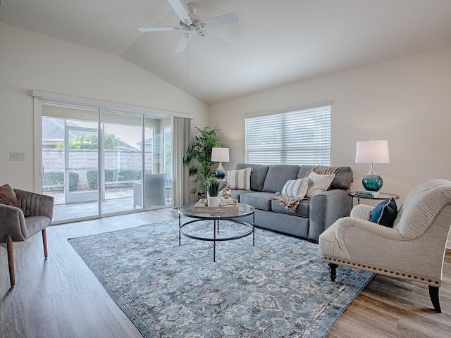 living room with lofted ceiling, ceiling fan, a healthy amount of sunlight, and light wood-type flooring