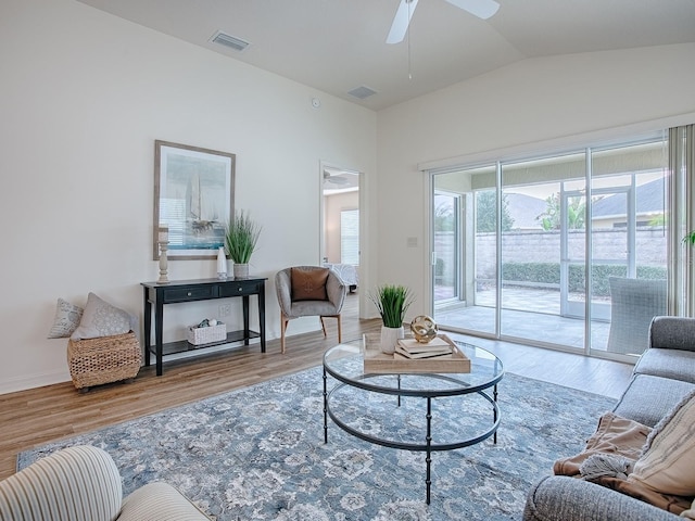 living room featuring hardwood / wood-style flooring, ceiling fan, and vaulted ceiling