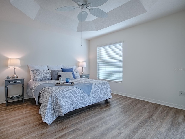 bedroom with wood-type flooring, ceiling fan, and a textured ceiling