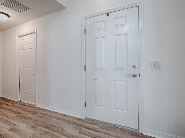 interior space featuring light hardwood / wood-style flooring and a textured ceiling