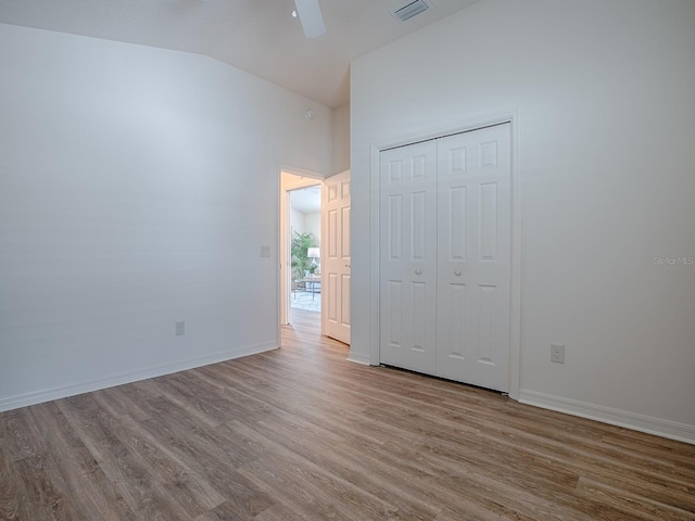 unfurnished bedroom with vaulted ceiling, ceiling fan, light hardwood / wood-style floors, and a closet