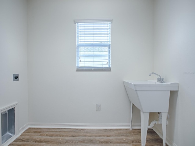 laundry area featuring hookup for an electric dryer and light hardwood / wood-style floors