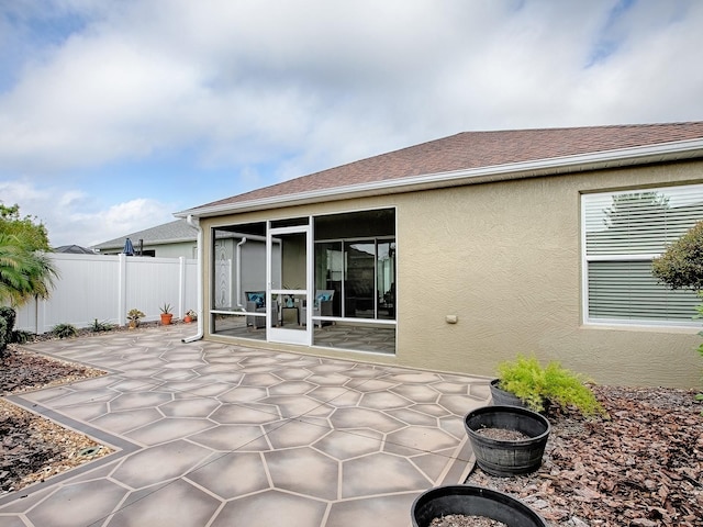 rear view of house with a sunroom and a patio