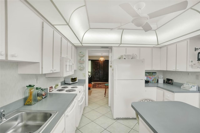 kitchen with white appliances, sink, light tile patterned flooring, ceiling fan, and white cabinets