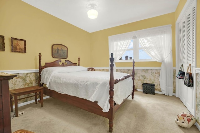 bedroom with light carpet and lofted ceiling