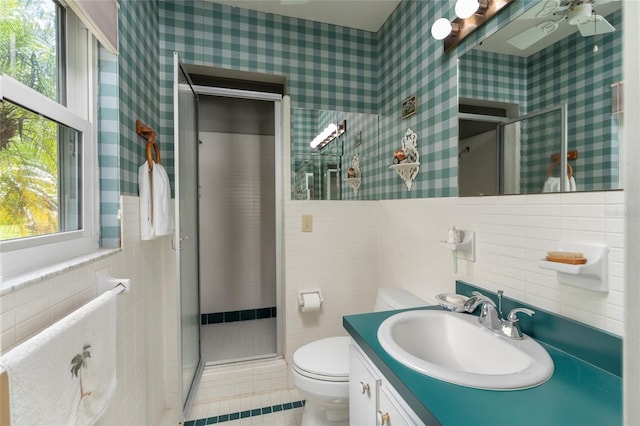 bathroom with toilet, tile walls, and vanity