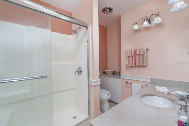 bathroom featuring sink, a shower with shower door, and toilet