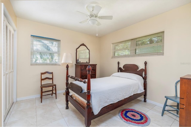 bedroom with ceiling fan, light tile patterned floors, and a closet