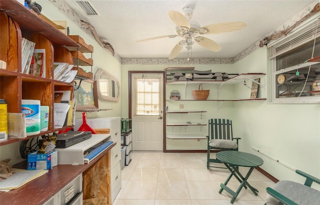 interior space with light tile patterned floors, ceiling fan, and a textured ceiling