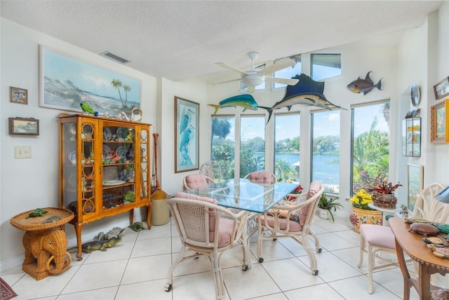 sunroom featuring a water view and ceiling fan