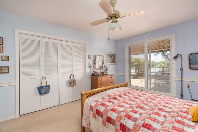 bedroom with a closet, access to outside, light colored carpet, and ceiling fan