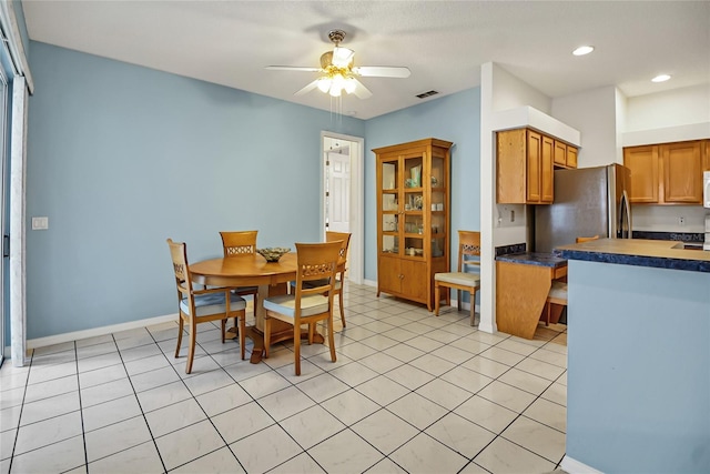 tiled dining area with ceiling fan