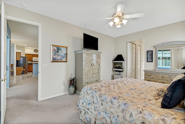 bedroom with light carpet, stainless steel fridge, and ceiling fan