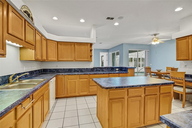 kitchen featuring sink, light tile patterned floors, ceiling fan, a center island, and white dishwasher