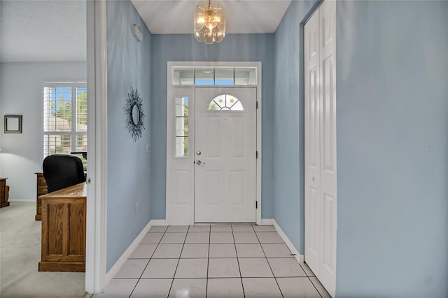 foyer with a chandelier and light tile patterned flooring