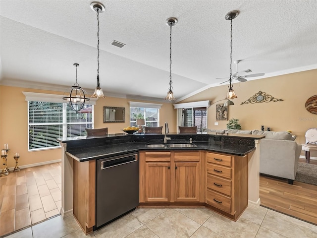 kitchen with an island with sink, dishwasher, sink, and hanging light fixtures