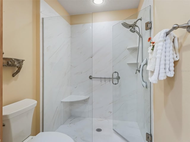 bathroom featuring toilet and an enclosed shower