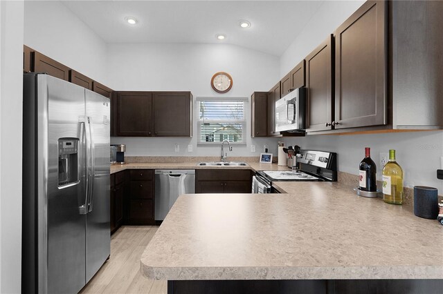 kitchen with sink, appliances with stainless steel finishes, dark brown cabinetry, vaulted ceiling, and kitchen peninsula