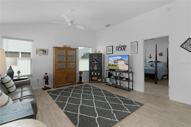 living room with hardwood / wood-style flooring, ceiling fan, and lofted ceiling