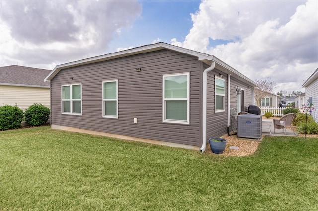 view of property exterior featuring a yard, a patio area, and central air condition unit