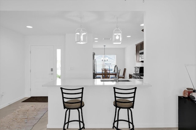1392 Kenneth St, The Villages, FL 34762 - kitchen featuring sink, pendant lighting, a breakfast bar, and kitchen peninsula