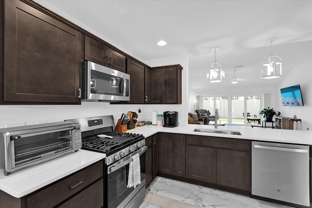1392 Kenneth St, The Villages, FL 34762 - kitchen with appliances with stainless steel finishes, decorative light fixtures, sink, ceiling fan, and kitchen peninsula