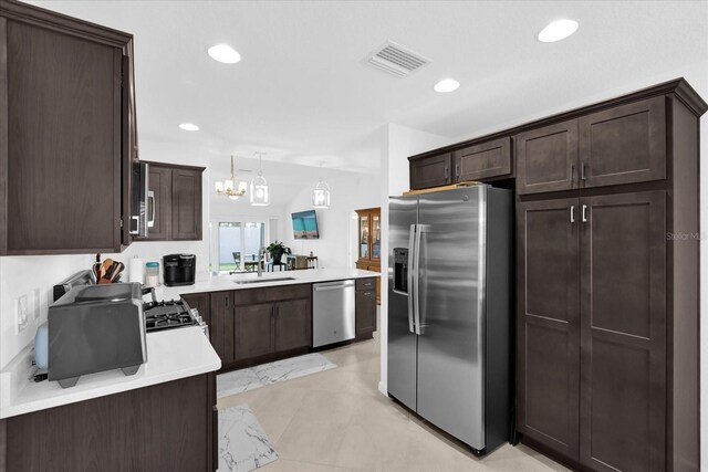 1392 Kenneth St, The Villages, FL 34762 - kitchen with dark brown cabinetry, stainless steel appliances, decorative light fixtures, and sink