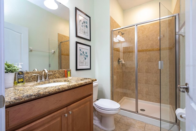 bathroom with walk in shower, vanity, toilet, and tile patterned flooring