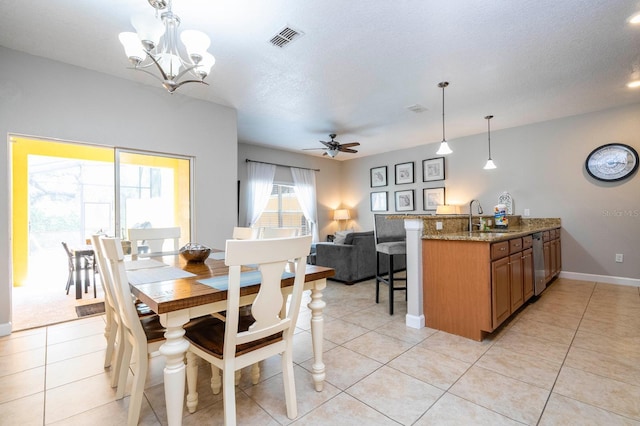 tiled dining area with sink, ceiling fan with notable chandelier, and a textured ceiling