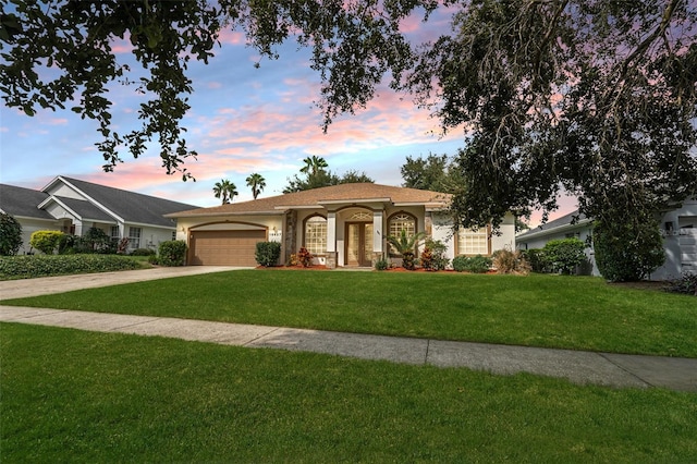 view of front facade with a garage and a yard