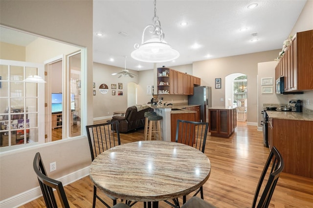 dining room with ceiling fan and light hardwood / wood-style floors