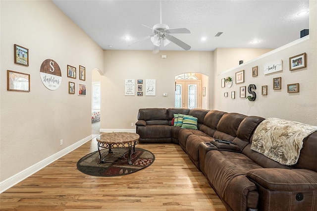 living room with french doors, ceiling fan, a wealth of natural light, and light wood-type flooring