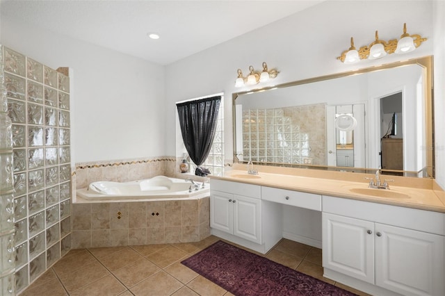 bathroom featuring vanity, tile patterned flooring, and tiled tub