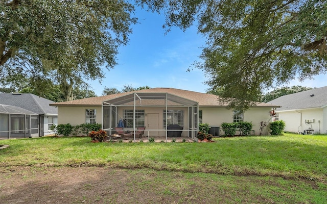 back of property featuring a lanai, central AC unit, and a lawn