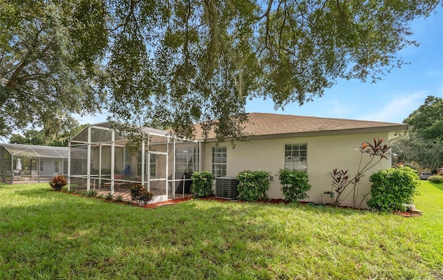 back of property featuring central AC, a yard, and a lanai