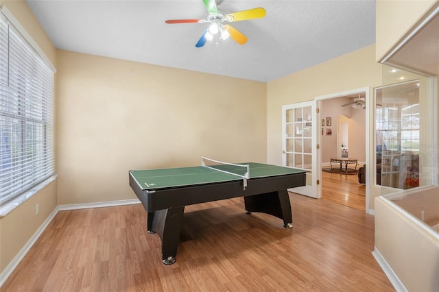 rec room featuring light hardwood / wood-style flooring, ceiling fan, and french doors