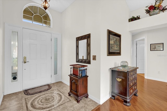 entryway featuring high vaulted ceiling and light wood-type flooring