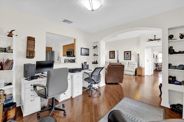 home office featuring hardwood / wood-style floors and a textured ceiling