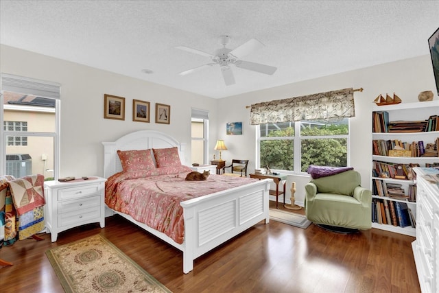 bedroom featuring ceiling fan, dark wood-type flooring, and a textured ceiling