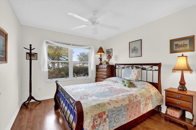 bedroom with ceiling fan and dark hardwood / wood-style flooring