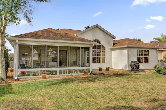 back of house featuring a sunroom and a yard