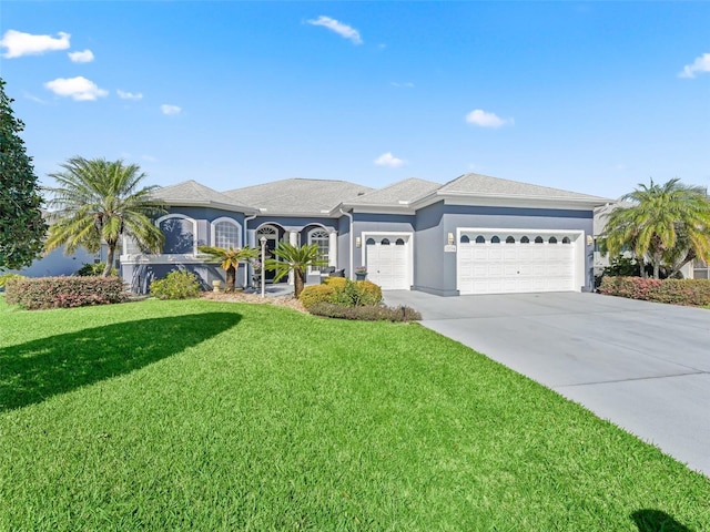 view of front of home featuring driveway, a front yard, an attached garage, and stucco siding