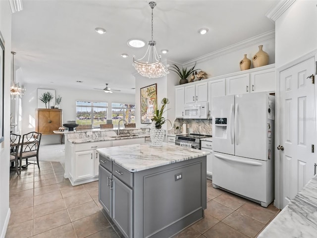 kitchen featuring a peninsula, white appliances, a kitchen island, and white cabinets