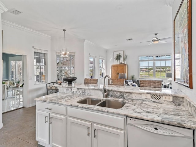 kitchen featuring light stone counters, a sink, white cabinets, dishwasher, and plenty of natural light