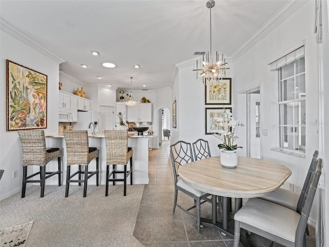 tiled dining room with recessed lighting, crown molding, a sink, baseboards, and an inviting chandelier