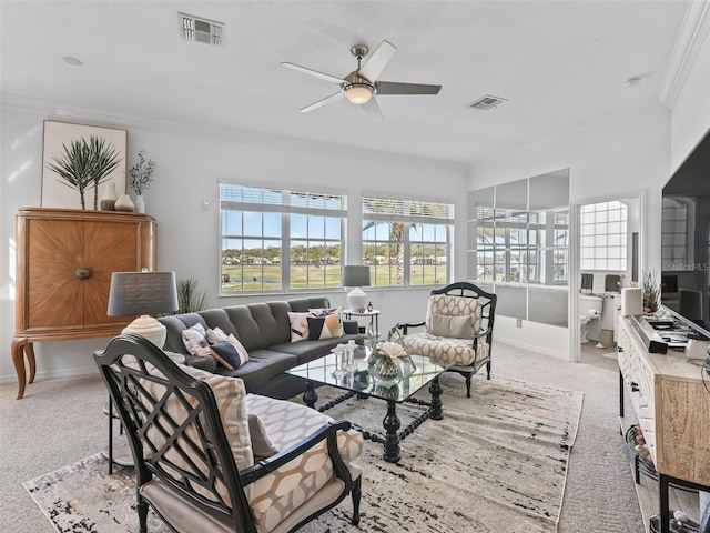 living area featuring ornamental molding, a ceiling fan, visible vents, and light colored carpet