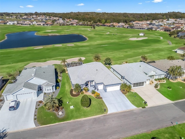 drone / aerial view featuring view of golf course, a water view, and a residential view