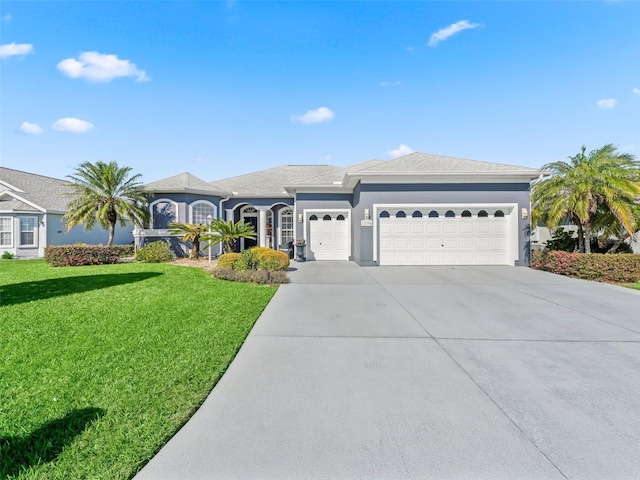 view of front of home with a garage, a front yard, concrete driveway, and stucco siding