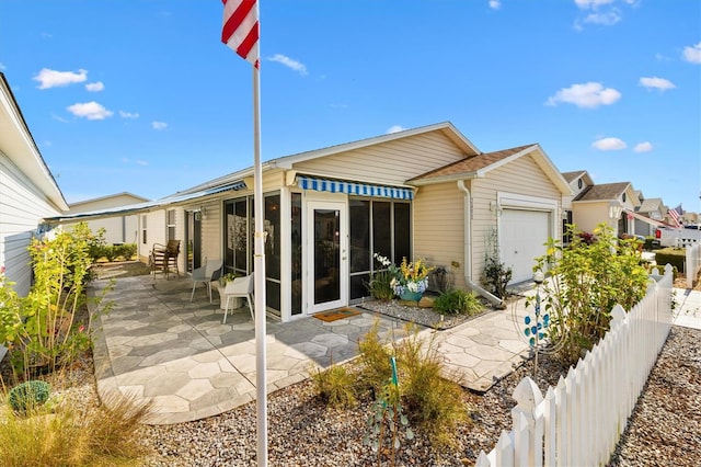 rear view of house featuring a garage and a patio area